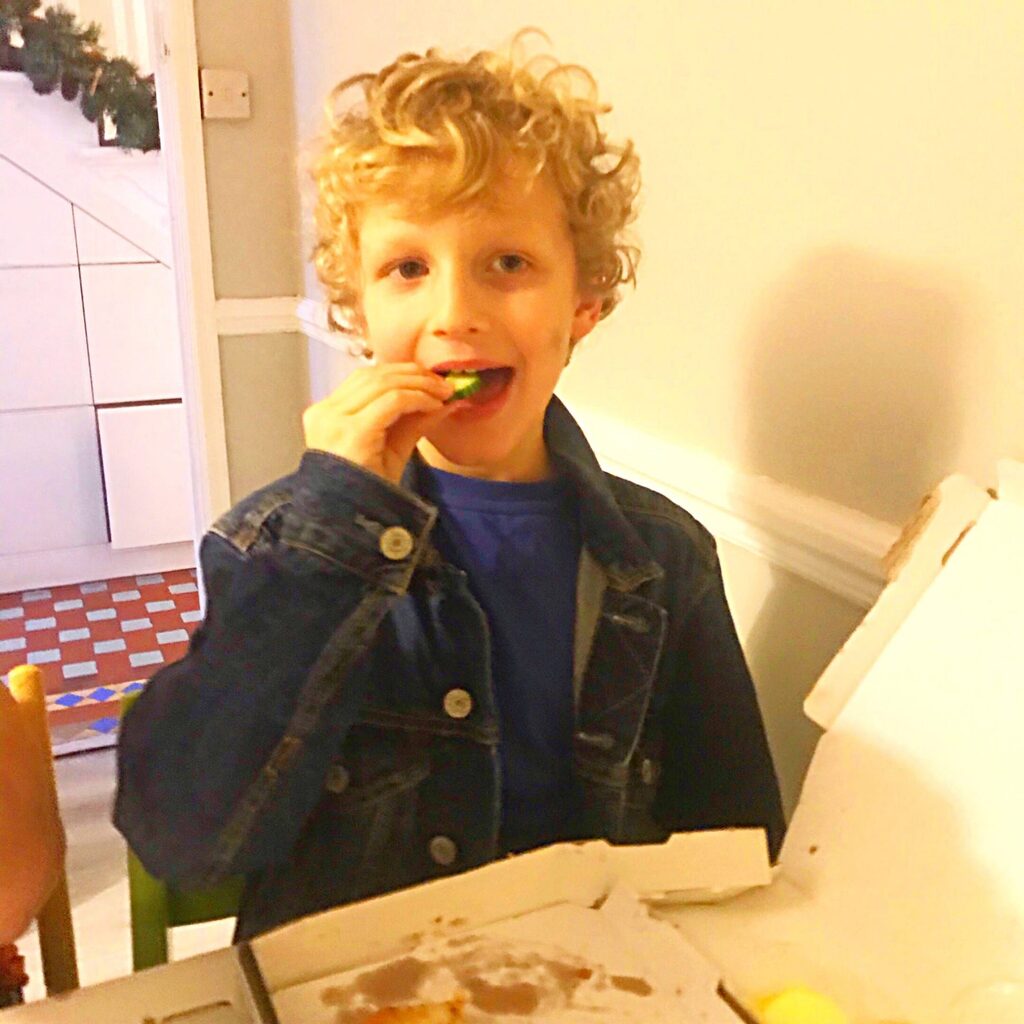 Boy eating cucumber on family night