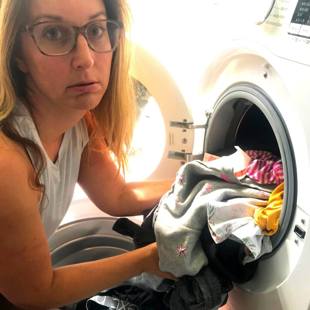 Creating me time - woman with grumpy face at the washing machine